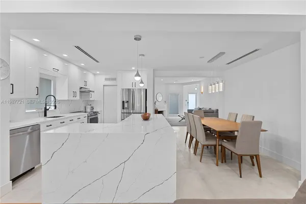 a large white kitchen with furniture and a dining table