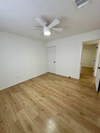 a view of empty room with wooden floor