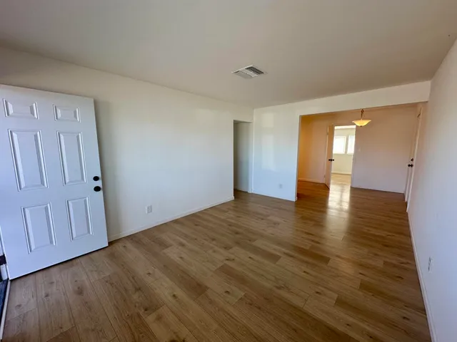 a view of empty room with wooden floor