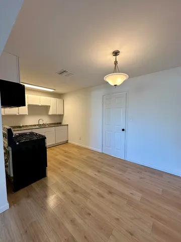 a kitchen with a stove and a wooden floor