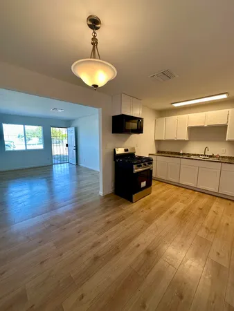a large kitchen with cabinets and wooden floor