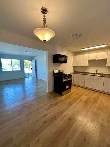a large kitchen with cabinets and wooden floor