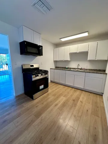 a kitchen with granite countertop a stove and a sink