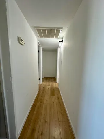 a view of a hallway with wooden floor