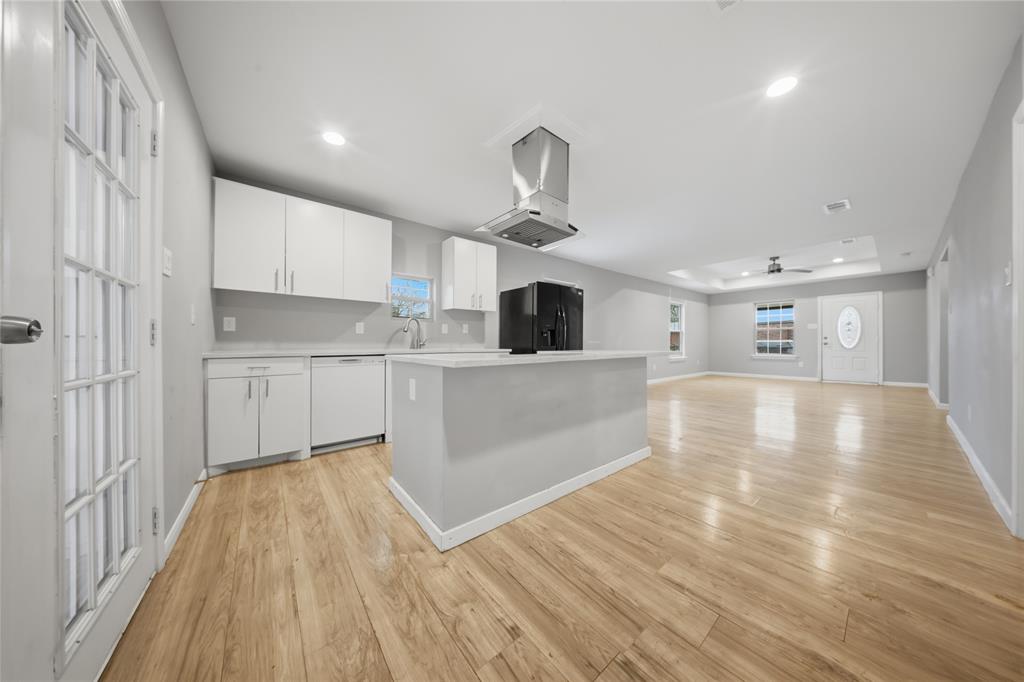 2350 West Cherry Street Paris, TX 75460 - Photo 1 of 18 a view of a kitchen with kitchen island a sink wooden floor and stainless steel appliances