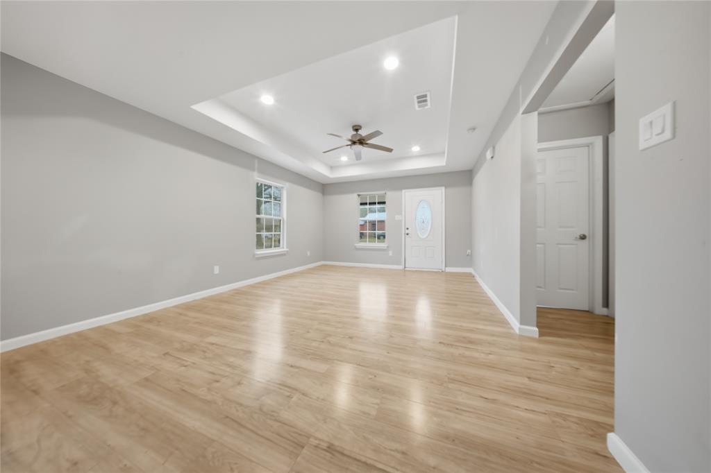 2350 West Cherry Street Paris, TX 75460 - Photo 6 of 18 a view of empty room with wooden floor and fan