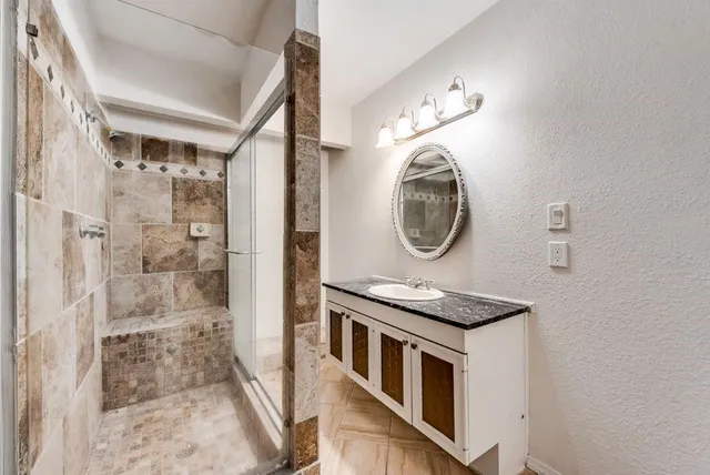 a bathroom with a sink a mirror and a shower