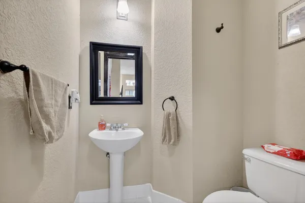 a bathroom with a sink toilet and a mirror