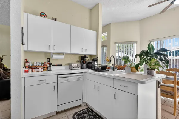 a kitchen with white cabinets and sink