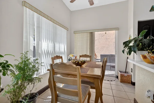 a dining room with furniture and potted plants
