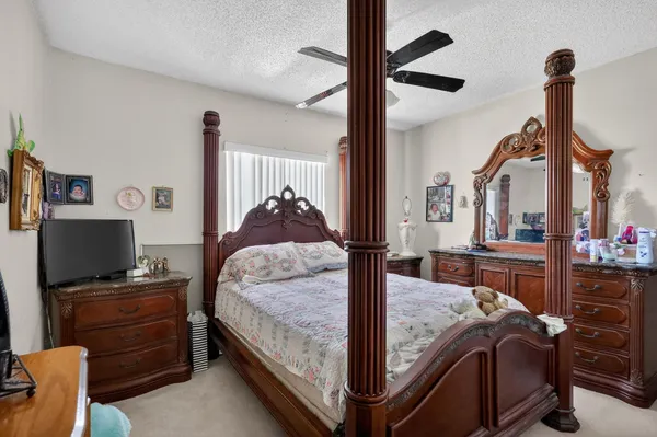 a bedroom with a bed and a large mirror on the dresser