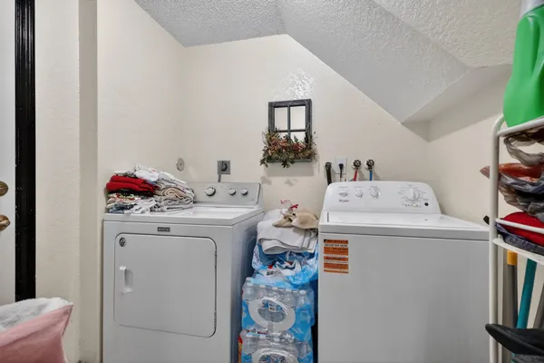 a utility room with dryer washer and a view of living room