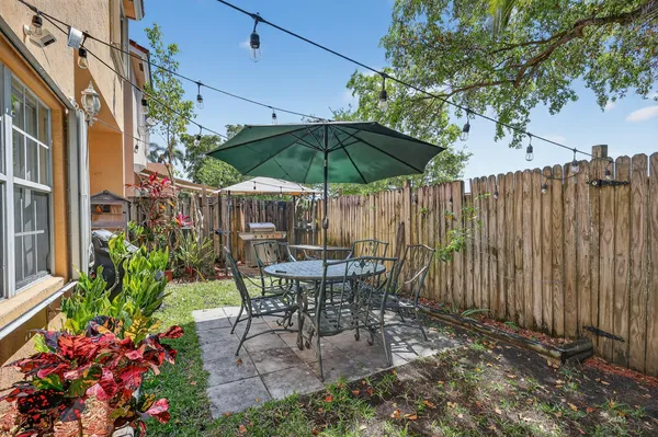 a backyard of a house with barbeque oven fire pit table and chairs