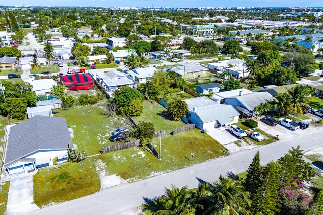 an aerial view of residential houses with outdoor space and trees