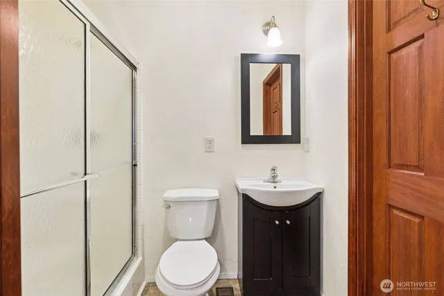 a bathroom with a toilet a sink and mirror