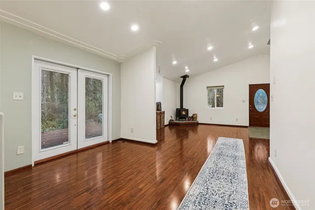 a view of a big room with wooden floor and windows