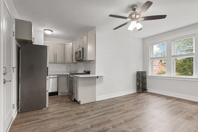 a kitchen with a refrigerator cabinets and wooden floor