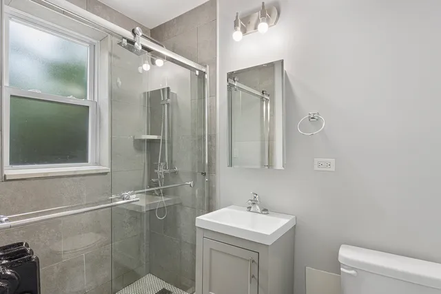 a bathroom with a sink a toilet and shower