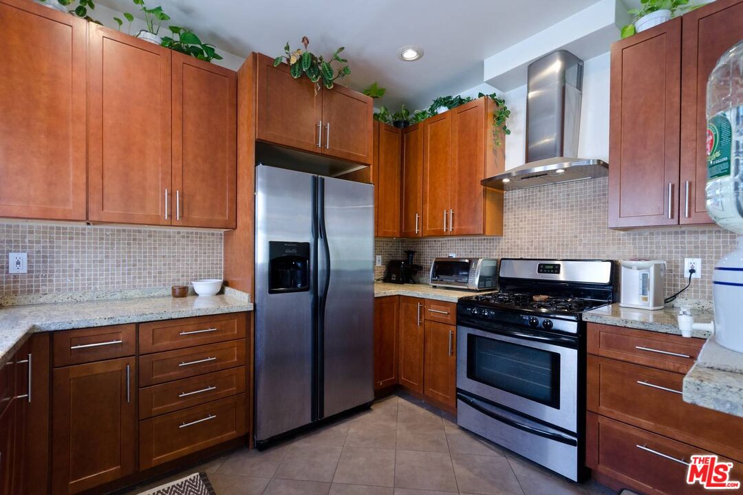 506 North Spaulding Avenue Los Angeles, CA 90036 - Photo 9 of 23 a kitchen with stainless steel appliances granite countertop a refrigerator and a stove top oven