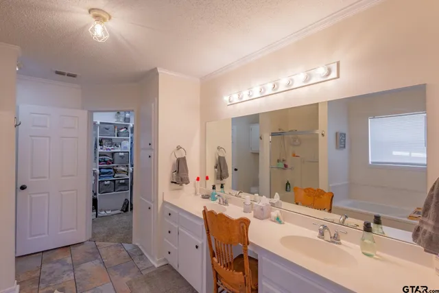 a spacious bathroom with a double vanity sink a large mirror and a shower