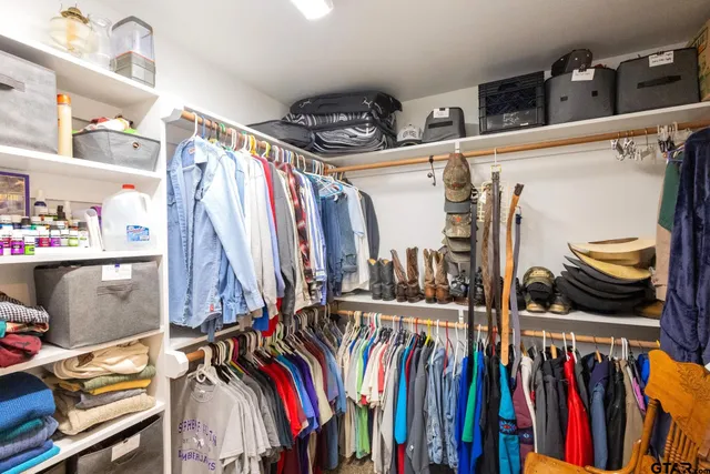 a view of walk in closet with clothes and shoes