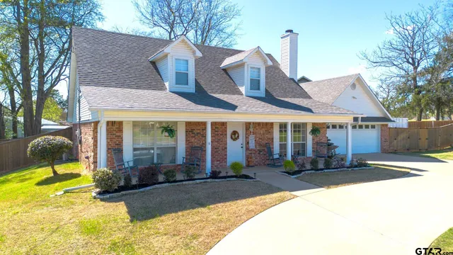 a front view of a house with a yard outdoor seating and garage