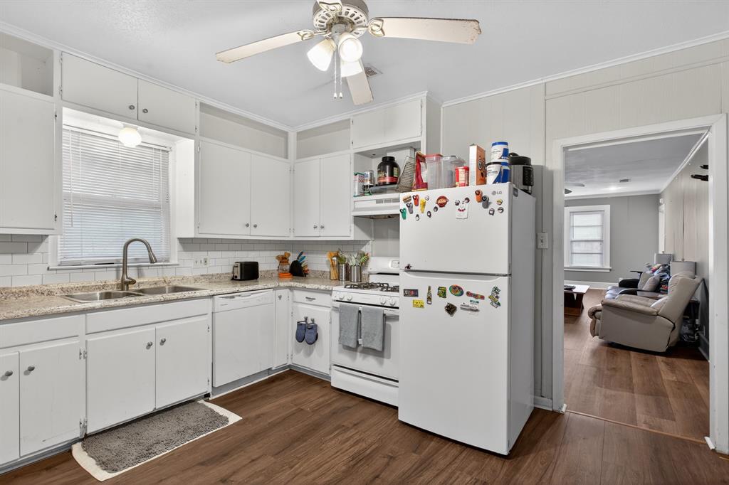 1111 North Austin Street Denton, TX 76201 - Photo 10 of 28 a white kitchen with a sink dishwasher a refrigerator and cabinets