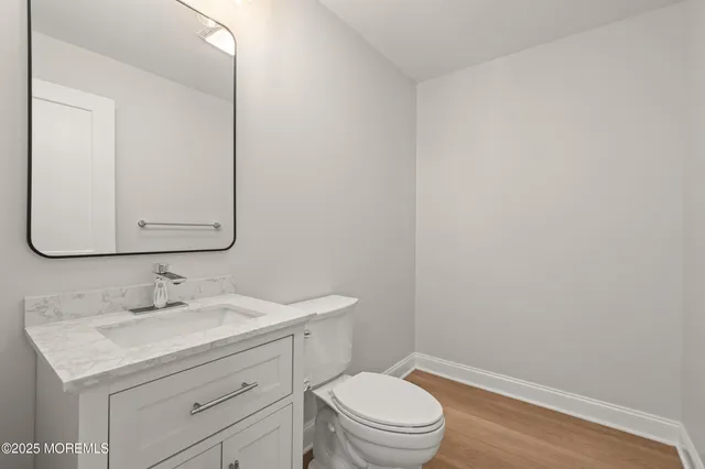 a bathroom with a granite countertop toilet sink and mirror