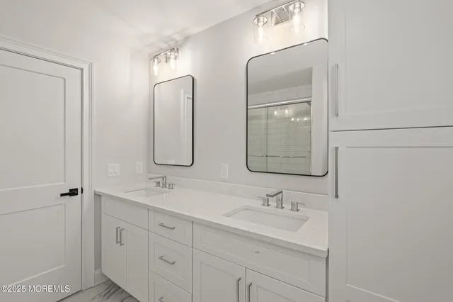 a bathroom with double vanity sinks and a mirror