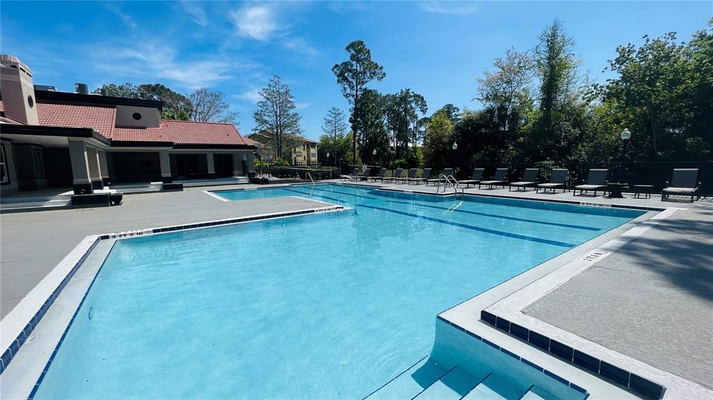 5120 Conroy Road, Unit 13 Orlando, FL 32811 - Photo 13 of 21 a view of a pool with lawn chairs under an umbrella