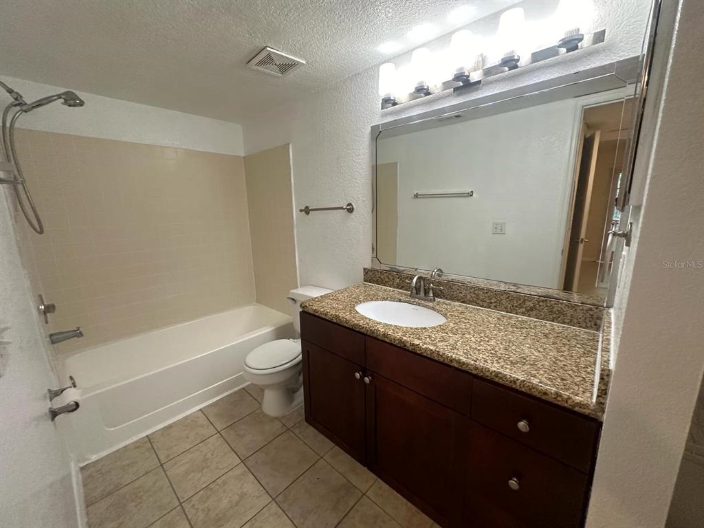 5120 Conroy Road, Unit 13 Orlando, FL 32811 - Photo 10 of 21 a bathroom with a granite countertop sink toilet and shower