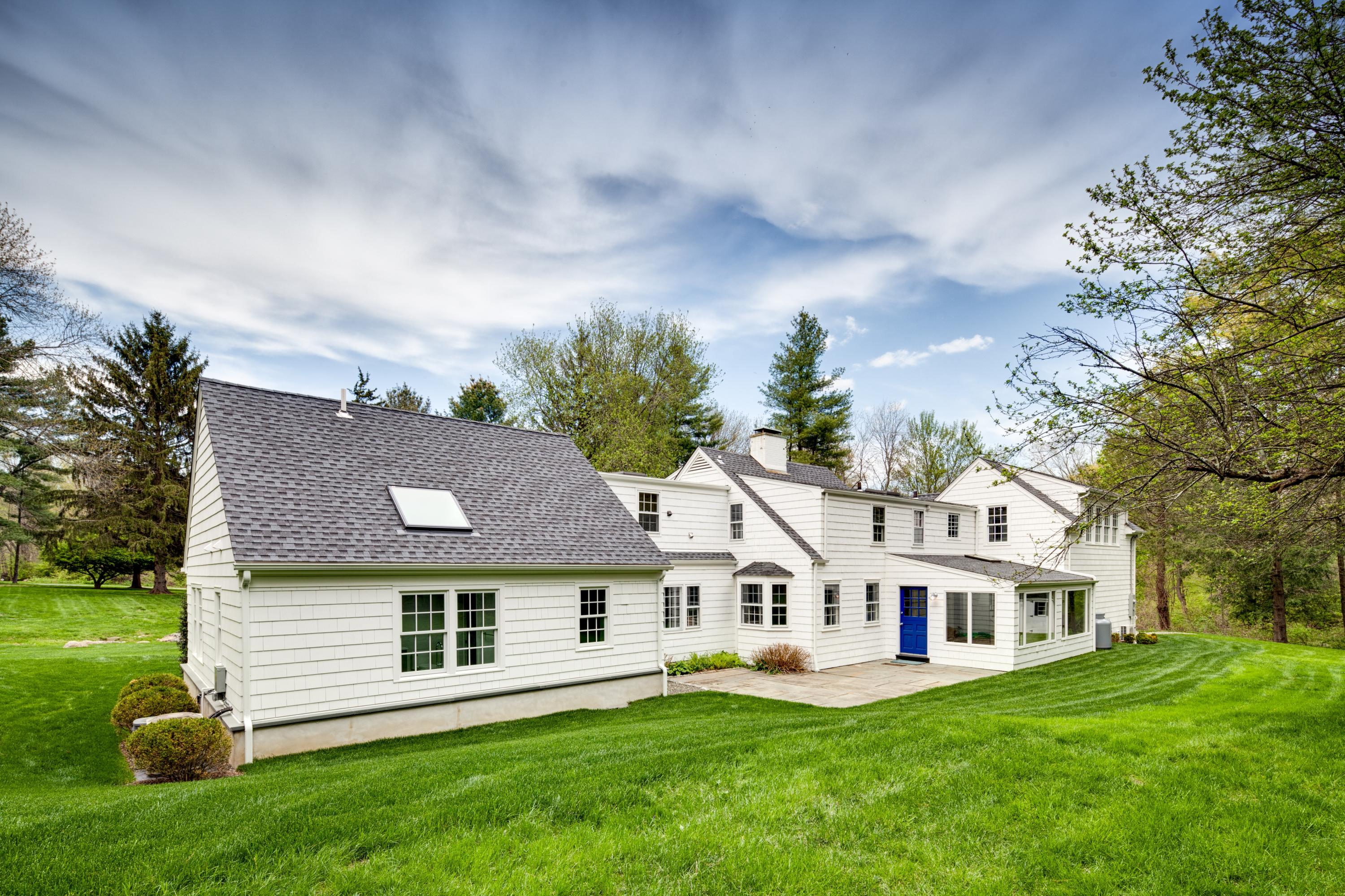 61 Juniper Road New Canaan, CT 06840 - Photo 17 of 17 a front view of a house with a garden and trees