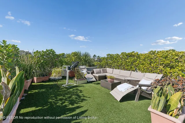 a view of a garden with lawn chairs and a fire pit