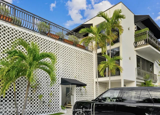 a roof deck with table and potted plants