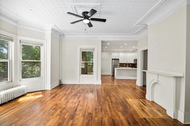 a view of a kitchen with a sink dishwasher a refrigerator with wooden floor and a dining table