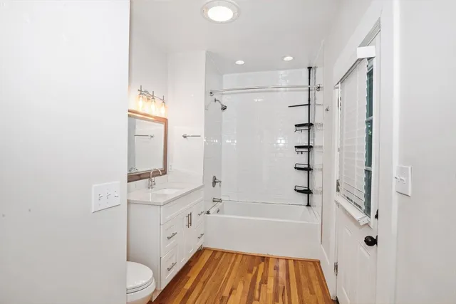 a bathroom with a bathtub shower sink vanity and toilet