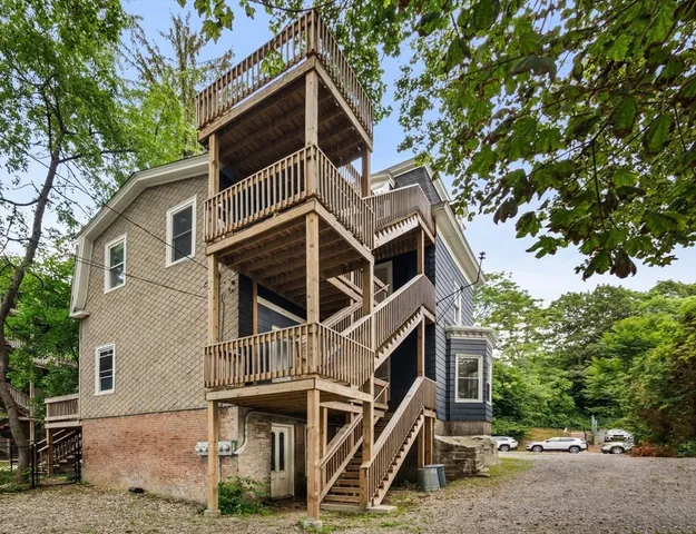a front view of a house with a tree