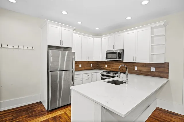 a kitchen with a refrigerator a stove a microwave and cabinets