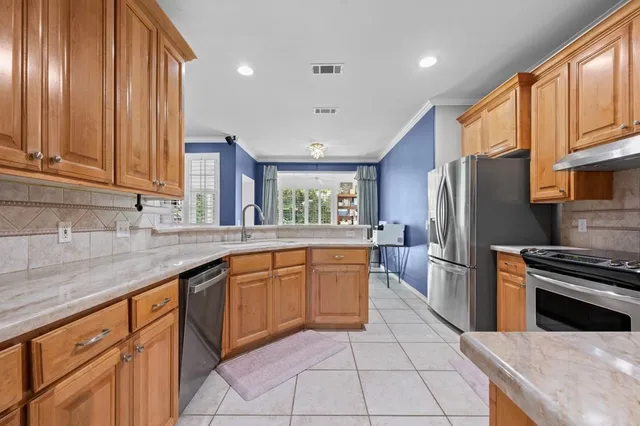 a kitchen with stainless steel appliances granite countertop a refrigerator and a sink