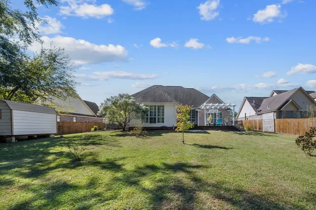 a view of a big house with a big yard and large tree
