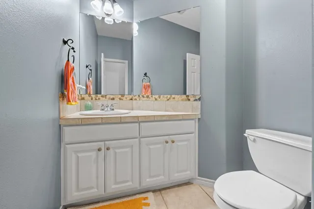 a bathroom with a sink vanity mirror and toilet