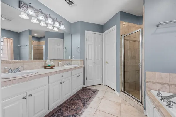 a spacious bathroom with a double vanity sink mirror and shower