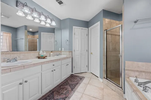 a spacious bathroom with a double vanity sink mirror and shower