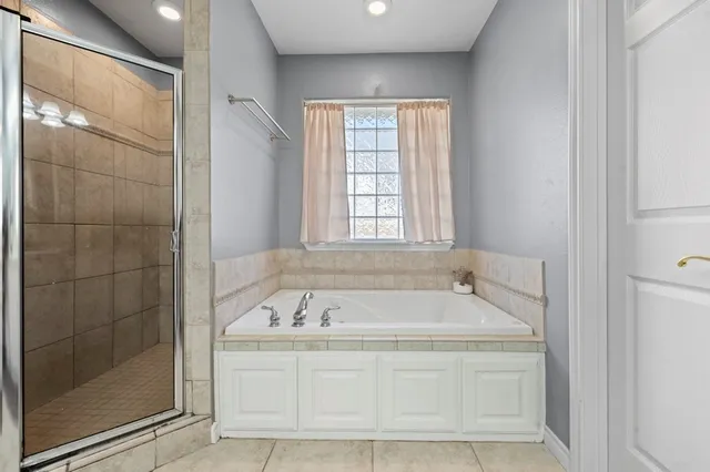 a spacious bathroom with a bathtub and shower