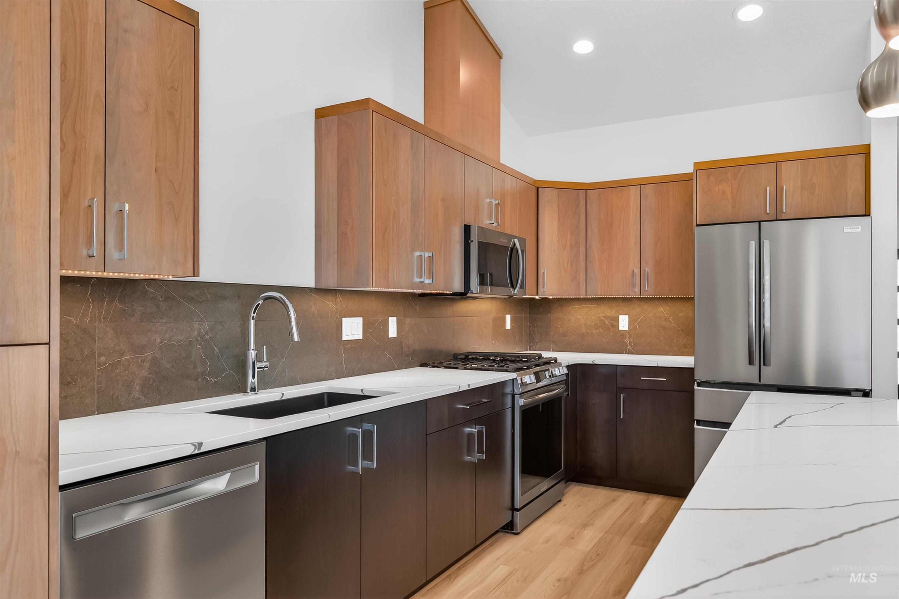 3710 22nd Street Lewiston, ID 83501 - Photo 21 of 36 Kitchen with stainless steel appliances, light wood-type flooring, light stone counters, backsplash, and recessed lighting
