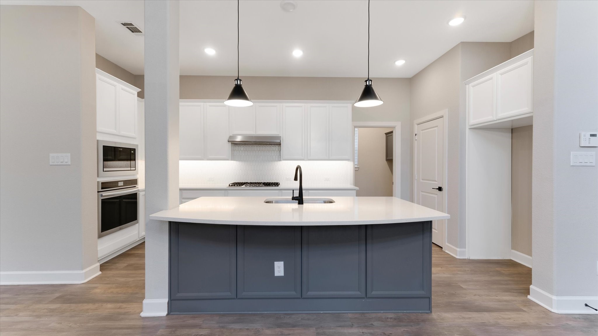 15607 Rising Wren Court Conroe, TX 77302 - Photo 9 of 40 a kitchen with kitchen island a sink stainless steel appliances and wooden floor