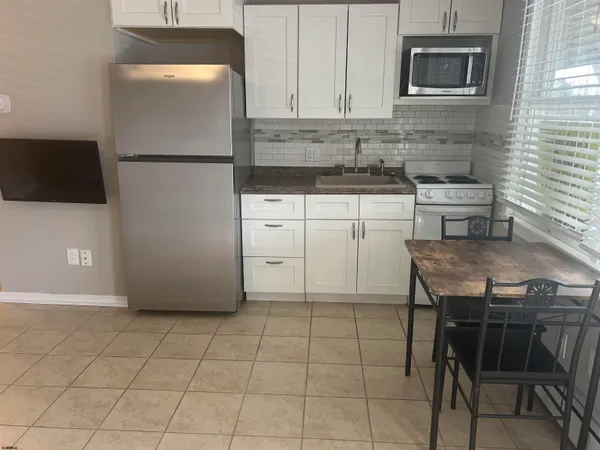 a kitchen with a stove a refrigerator and cabinets