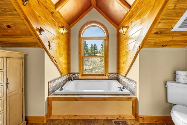 a view of bathroom with a tub and window