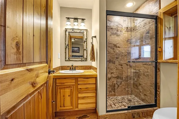 a bathroom with a granite countertop sink and a mirror