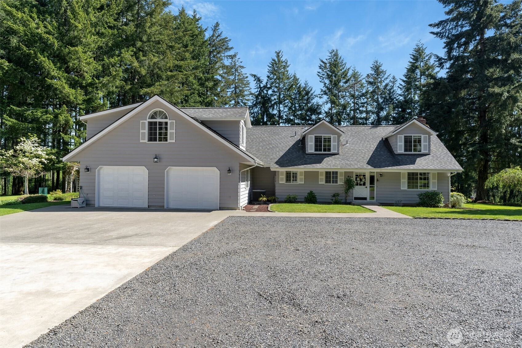 a front view of a house with a yard and trees